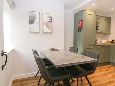 a kitchen and dining room with a table and chairs at Riverside Cottage No 5 in Keswick