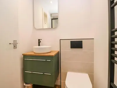 a bathroom with a sink and a mirror at Riverside Cottage No 5 in Keswick
