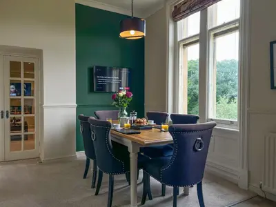 a dining room with a table and blue chairs at Geltsdale Wing, Wetheral 1st floor apartment with countryside views, close to pub & restaurant in Wetheral