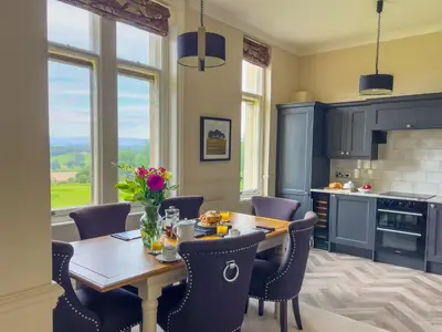 a kitchen with a wooden table with chairs and a dining room at Geltsdale Wing, Wetheral 1st floor apartment with countryside views, close to pub & restaurant in Wetheral