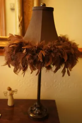 a lamp sitting on a table with a flower on it at Elm Tree Lodge in Keswick