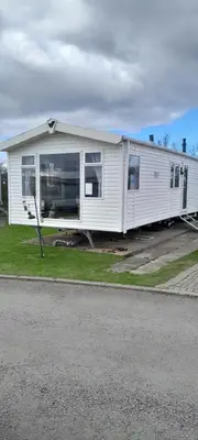 a mobile home is parked on the side of the road at Arual Caravan Manor House Park. Allonby, Cumbria in Maryport