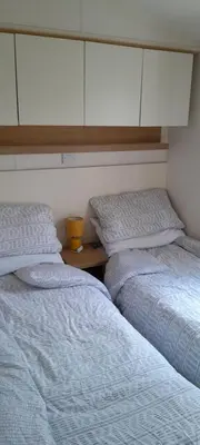 two beds sitting next to each other in a bedroom at Arual Caravan Manor House Park. Allonby, Cumbria in Maryport