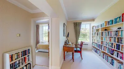 a room with bookshelves and a desk and a bedroom at Airds of Kells House in Castle Douglas
