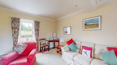 a living room with two couches and a window at Airds of Kells House in Castle Douglas