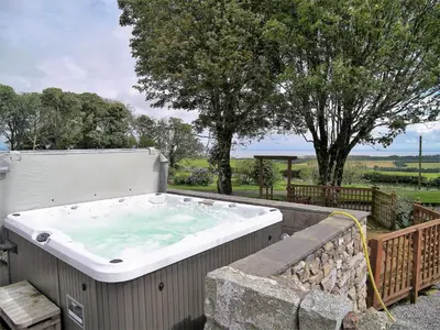 a large hot tub in a stone wall with trees at Criffel Glen in Dumfries