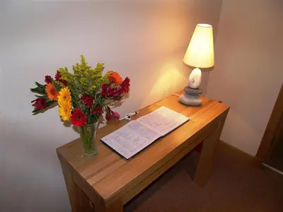 a table with a vase of flowers and a lamp at Criffel Glen in Dumfries