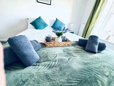 a bedroom with a bed with blue pillows at The Georgian Townhouse - 4 Bedrooms - Sleeps 9 in Whitehaven