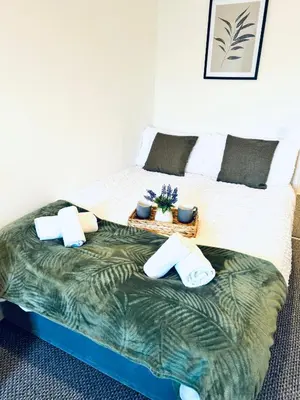 a bedroom with a large bed with avertisementatronatronstrationstration at The Georgian Townhouse - 4 Bedrooms - Sleeps 9 in Whitehaven