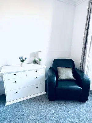 a living room with a chair and a dresser at The Georgian Townhouse - 4 Bedrooms - Sleeps 9 in Whitehaven