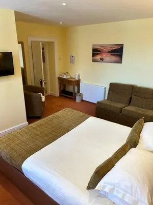 a bedroom with a large bed and a couch at Moresby Hall Country House Hotel in Whitehaven