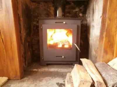 a stove in a room with a fire in it at Threecrofts Farm in Dumfries