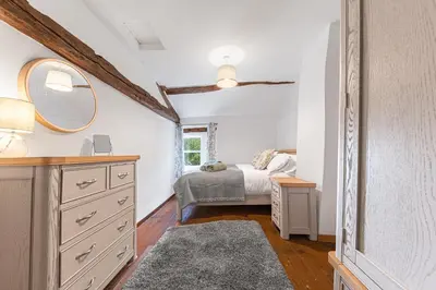 a bedroom with a bed and a mirror at Knott House Farm in Keswick
