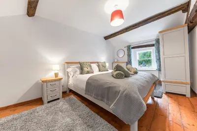 a bedroom with a large bed and a window at Knott House Farm in Keswick