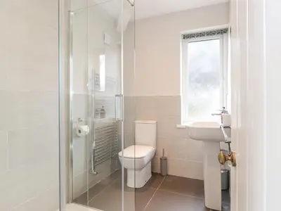 a bathroom with a shower and a toilet and a sink at 1 Millbank in Keswick