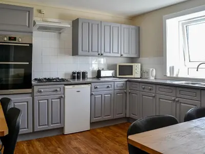 a kitchen with gray cabinets and a white appliances at Montys in Castle Douglas