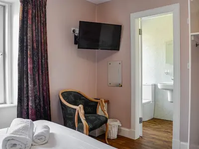 a hotel room with a bed and a tv on the wall at Montys in Castle Douglas