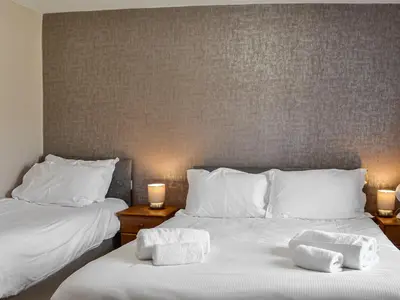 two beds with towels on them in a room at Montys in Castle Douglas