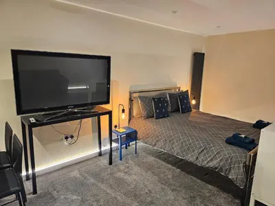 a bedroom with a large flat screen tv and a bed at Carlisle City Centre The Wash House in Carlisle