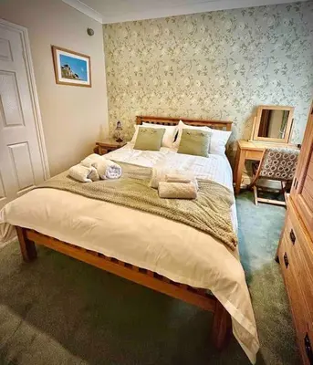 a bedroom with a large bed with towels on it at A charming luxury apartment! in Portinscale