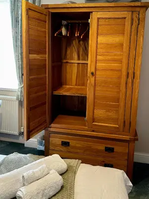 a wooden hutch with two towels in a bedroom at A charming luxury apartment! in Portinscale