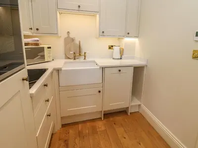 a kitchen with white cabinets and a sink at The Pavillion in Carlisle