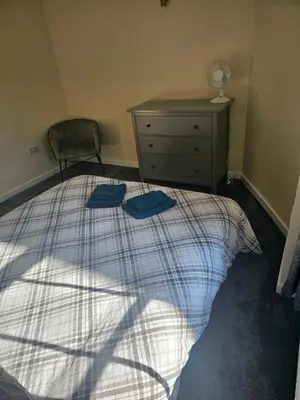 a bedroom with a bed with two blue towels on it at Carlisle City Centre. The Foremans Residence. in Carlisle
