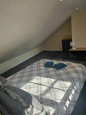 a bedroom with a bed with two blue clothes on it at Carlisle City Centre. The Foremans Residence. in Carlisle