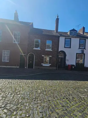 a cobblestone street in front of a brick building at Carlisle City Centre. The Foremans Residence. in Carlisle