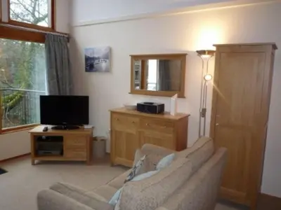 a living room with a couch and a television at Keswick Bridge 16, within walking distance of Keswick town centre, strictly no pets in Keswick
