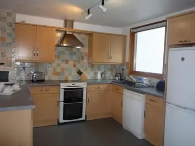 a kitchen with wooden cabinets and a white refrigerator at Keswick Bridge 19, within walking distance of Keswick town centre, strictly no pets in Keswick