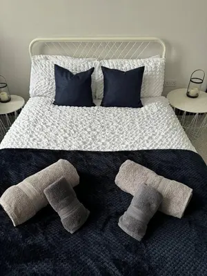 a large bed with four pillows and socks on it at Lowther Apartment - 2 Bedrooms - Sleeps 4 in Whitehaven
