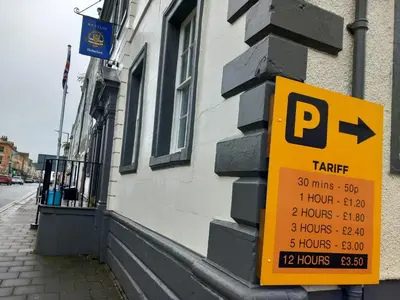 a yellow parking sign on the side of a building at Lowther Apartment - 2 Bedrooms - Sleeps 4 in Whitehaven