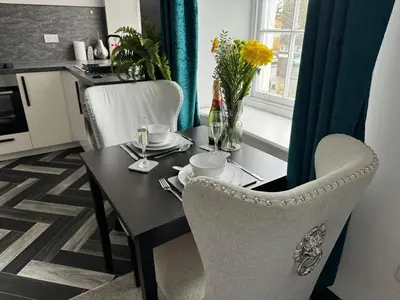 a kitchen with a table with chairs and a table and a tableablish at Lowther Apartment - 2 Bedrooms - Sleeps 4 in Whitehaven