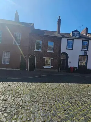 a cobblestone street in front of a brick building at Carlisle City Centre The Gavel in Carlisle