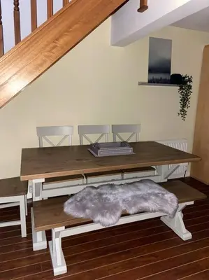 a dining room table with a bench with a rug on it at Lanfine View 1 at Loudoun Mains with Hot Tub in Newmilns