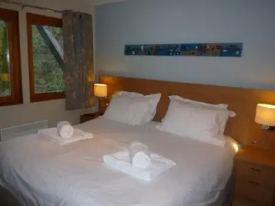 a bedroom with a white bed with two towels on it at Keswick Bridge 6, within walking distance of Keswick town centre, strictly no pets in Keswick