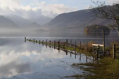 a body of water with a row of posts in the water at Bluestones in Keswick