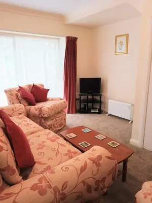 a living room with a couch and a table at Glen Dhoo Country Cottages - The Apartment in Onchan