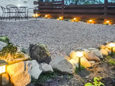 a garden with rocks and lights in front of a building at Criffel Cottage in Ruthwell