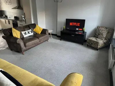 a living room with a couch and a tv at The Lowther Penthouse - 2 Bedrooms - Sleeps 4 in Whitehaven