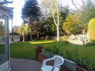 a white chair sitting on a fence in a yard at Number Fifty-Six Ramsey Villa in Ramsey