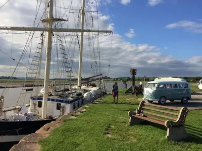 a van parked next to a dock with boats at Shorepark - waterfront cottage with stunning views in Dumfries