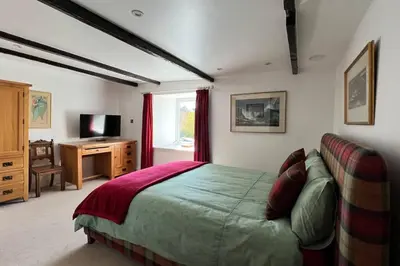 a bedroom with a bed and a television in it at Shorepark - waterfront cottage with stunning views in Dumfries