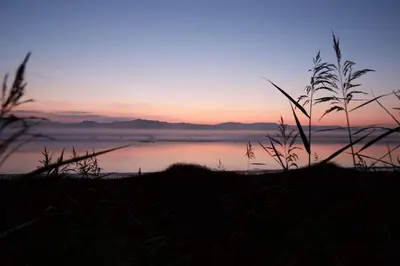 a sunset over a body of water with a view at Shorepark - waterfront cottage with stunning views in Dumfries