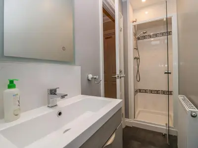 a white bathroom with a sink and a shower at Castle Crag in Keswick