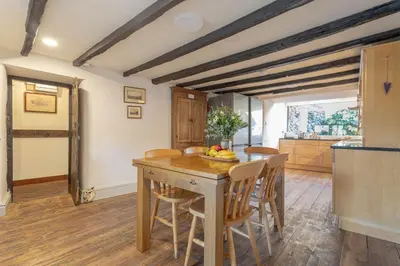 a kitchen and dining room with a wooden table and chairs at Goody Bridge Barn in Grasmere