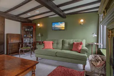 a living room with a green couch and a table at Goody Bridge Barn in Grasmere