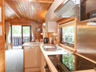 a kitchen in a tiny house with a balcony at Ennerdale Lodge in Keswick