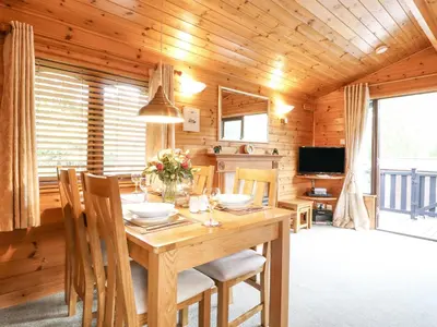 a wooden dining room with a table and chairs at Ennerdale Lodge in Keswick